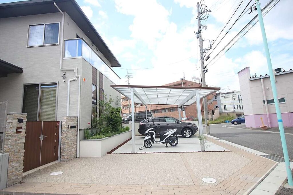 洋風モダンな外構に大型の二台用カーポートを設置。親しみやすい門扉を設置し、緑豊かな花壇も設置。