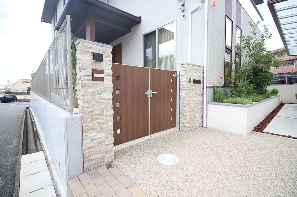 洋風モダンな外構に大型の二台用カーポートを設置。親しみやすい門扉を設置し、緑豊かな花壇も設置。