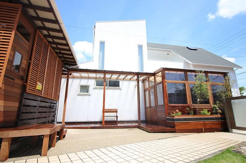 ガーデンルームで庭にくつろぎの空間を取り入れた事例。木製の特注ガーデンルームで庭と一体化できます。