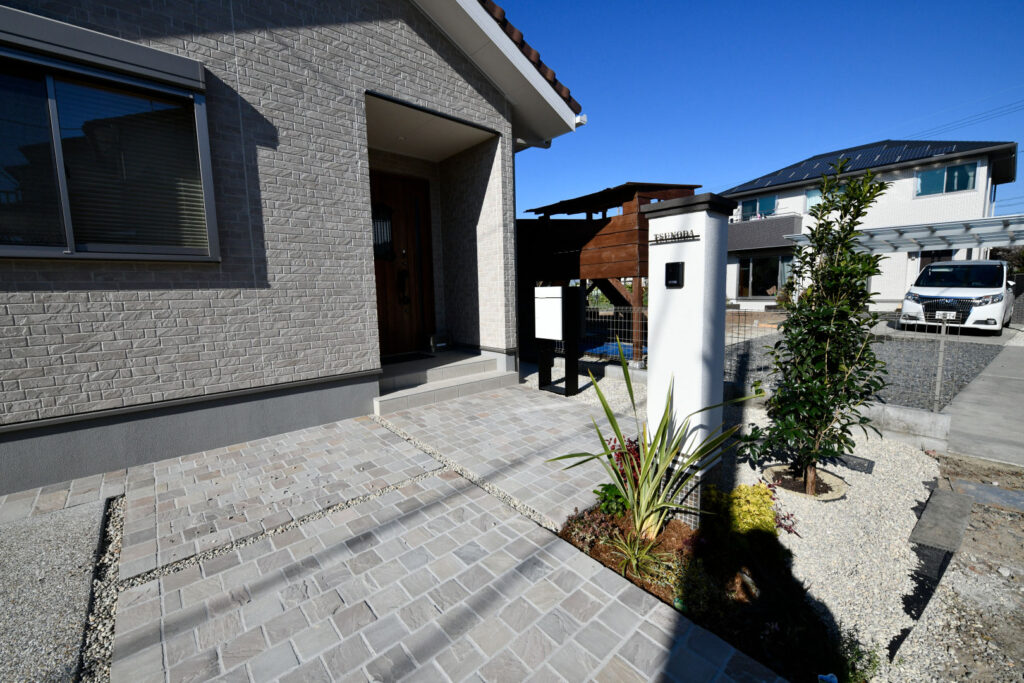 上品な佇まいの門柱とナチュラルモダンな外構の施工例。ワンポイントな植栽を最大限に活用。